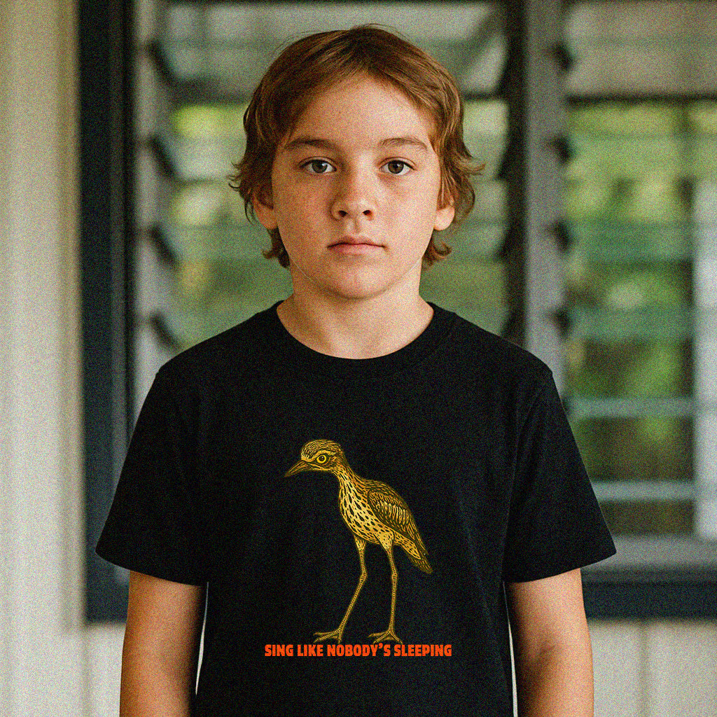 Model wearing Curlew kids graphic tee with illustrated bush stone-curlew, Darwin NT